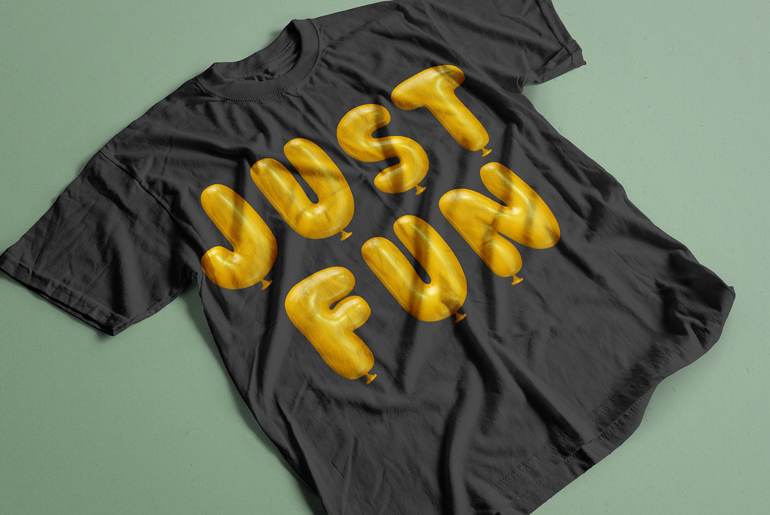 Yellow Balloon Font JUST FUN T-Shirt Black t-shirt on green with JUST FUN printed in the Yellow Balloon Font