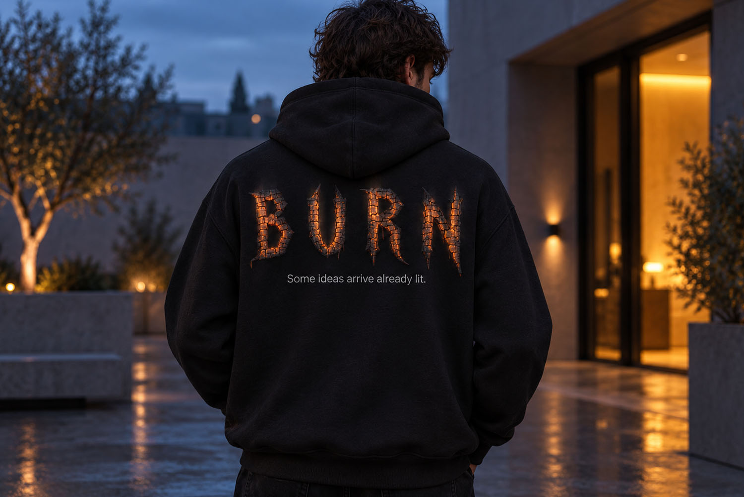 Burn Hell Font hoodie print Black hoodie printed with the word BURN in the Burn Hell Font, worn outdoors at dusk