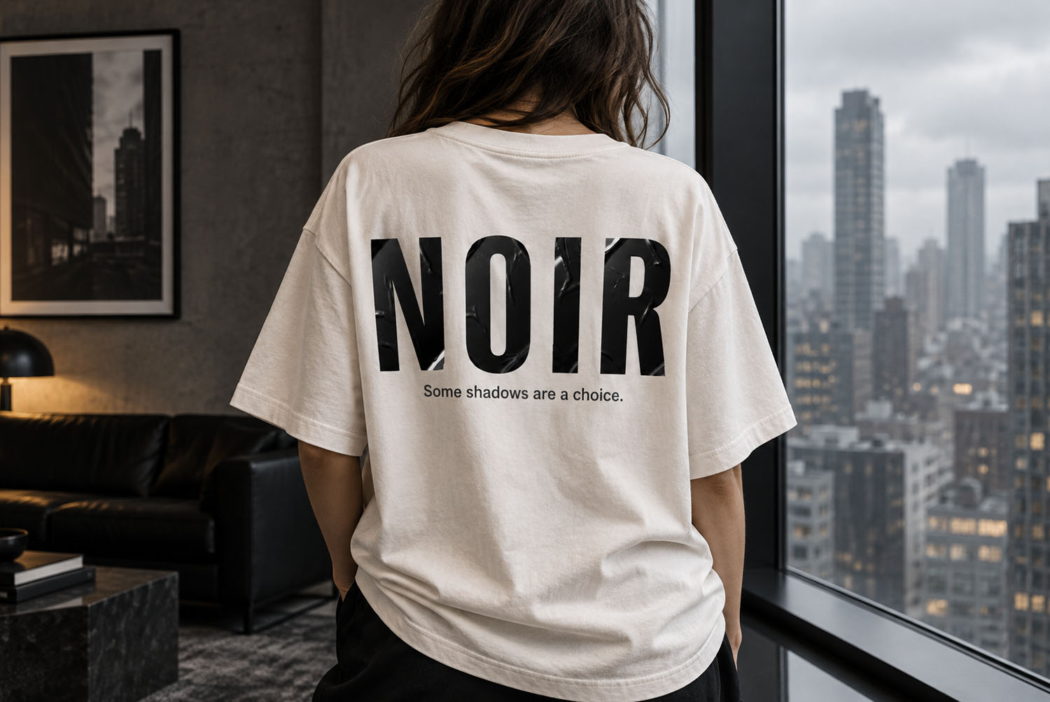 Noir Sticker Font NOIR T-Shirt Back of a white t-shirt printed with NOIR in the Noir Sticker Font by a city window