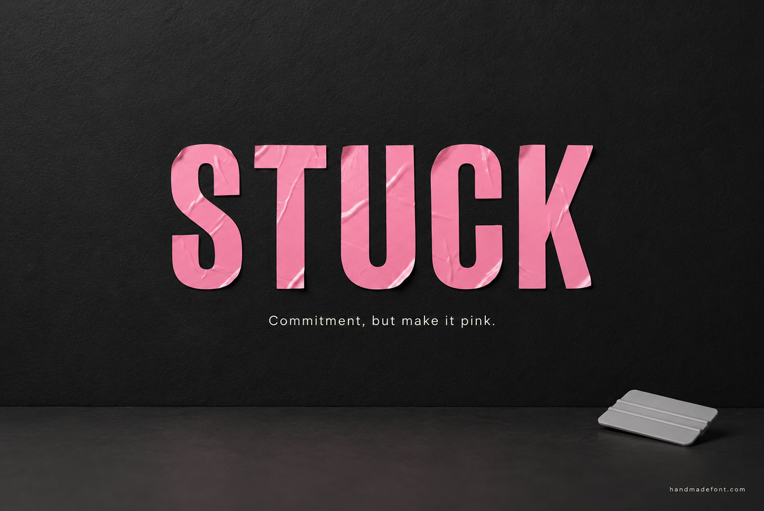 Pink Sticker Font Stuck Lettering The word STUCK in the Pink Sticker Font on a matte black wall